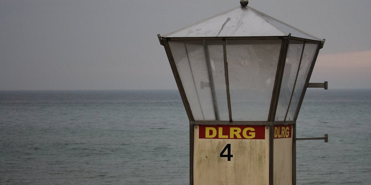 Deserted lifeguard tower on a sandy beach in Germany, overlooking a calm sea.